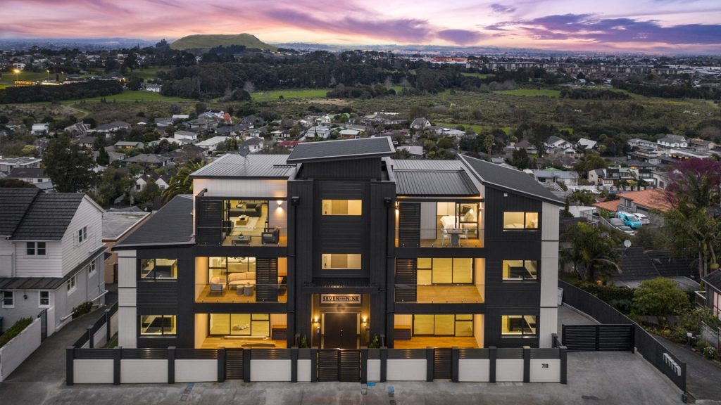 Modern apartment building with sunset backdrop.