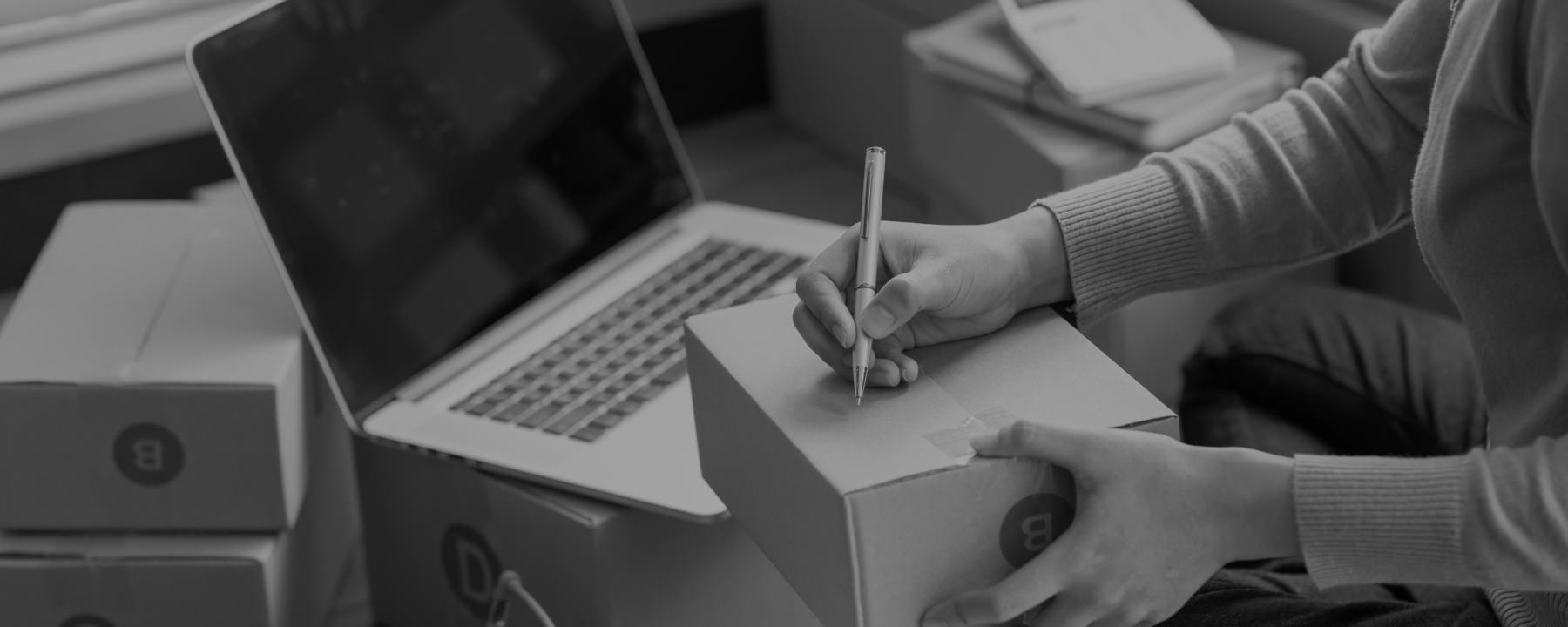 A person holds a pen and prepares to write something on the package